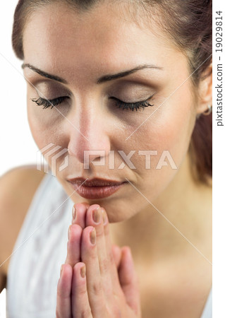Close-up of woman with eyes closed and joined hands 19029814