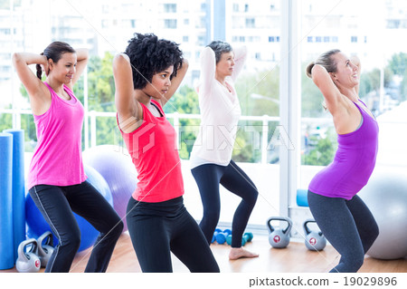 Women exercising with hands behind head 19029896