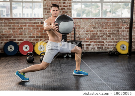 Portrait of muscular man exercising with medicine ball 19030095