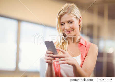 Beautiful businesswoman texting on phone 19030206
