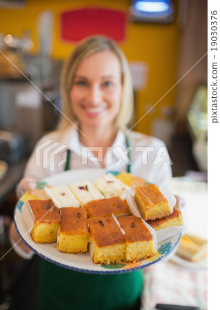 Female worker serving pastries Female worker serving pastries 19030376