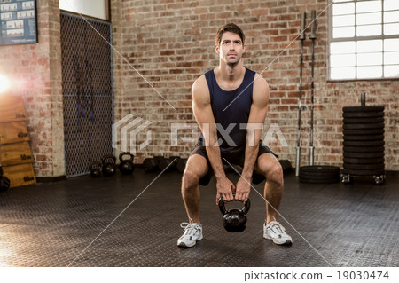 Man lifting kettlebell Man lifting kettlebell 19030474