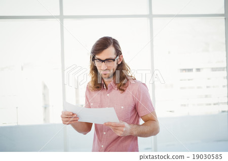 Confident hipster looking at documents 19030585