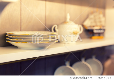 White plates and dinnerware in a cupboard White plates and dinnerware in a cupboard 19034077