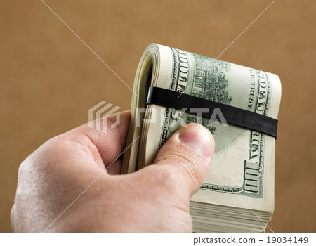 Hand holding $100 banknotes Hand holding $100 banknotes 19034149