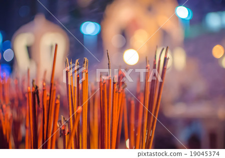 Red incense sticks burning in bokeh night 19045374