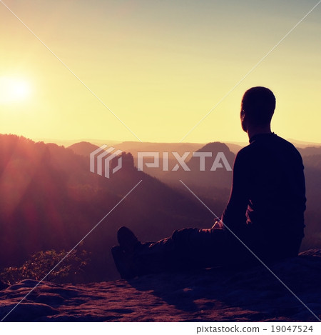 Hiker in black sportswear sit on mountain top 19047524