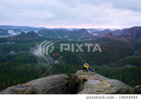 Rear view of tall hiker in yellow black jacket Rear view of tall hiker in yellow black jacket 19048994