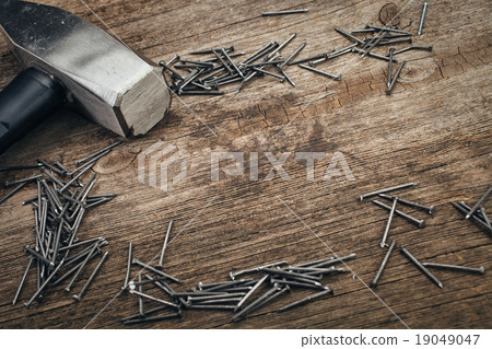 chrome Hammer and nails on wooden board 19049047