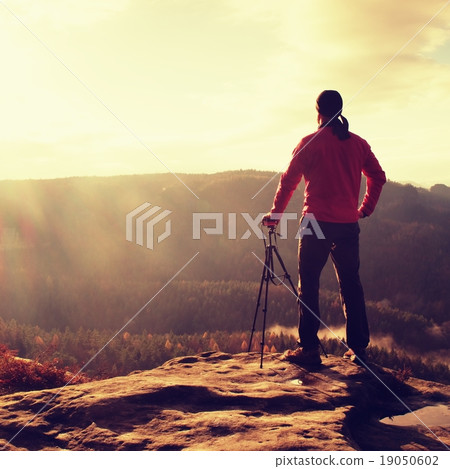 Nature photographer watch misty sunrise in valley  19050602