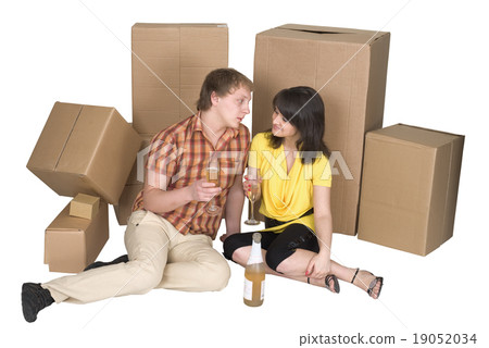 Girl and the guy drink champagne near boxes Girl and the guy drink champagne near boxes 19052034