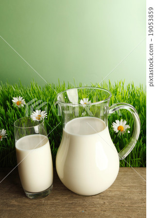 Glass of milk and jar on flower meadow Glass of milk and jar on flower meadow 19053859