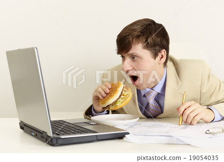 Young businessman is going to eat sandwich Young businessman is going to eat sandwich 19054035