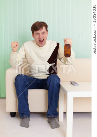 Football fan sitting on sofa with TV Football fan sitting on sofa with TV 19054036