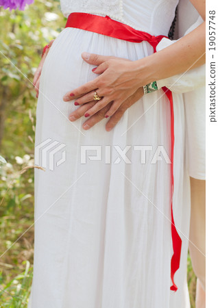 pregnant woman is touching her belly with hands pregnant woman is touching her belly with hands 19057748