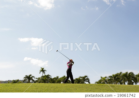 a man swinging golf on fairway 19061742