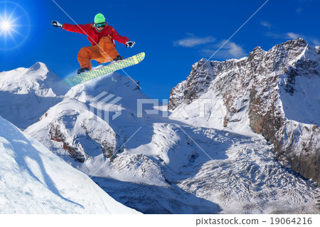 Snowboarder jumping against blue sky Snowboarder jumping against blue sky 19064216