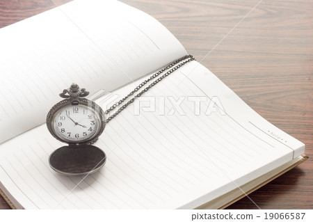 Notebook and old watch on working desk. Notebook and old watch on working desk. 19066587