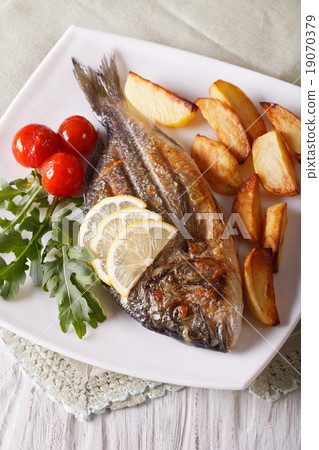 Grilled dorado fish with fried potatoes and tomato Grilled dorado fish with fried potatoes and tomato 19070379