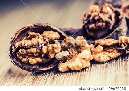 Walnut kernels and whole walnuts on wooden board. Walnut kernels and whole walnuts on wooden board. 19070618