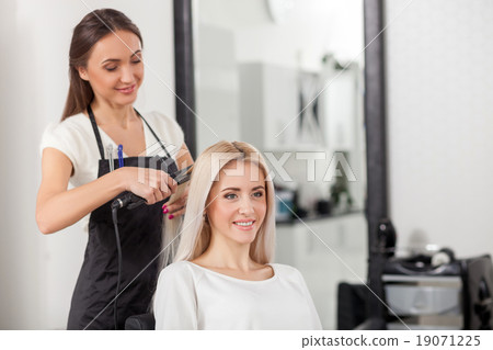 Pretty blond girl is attending hairdressing salon 19071225