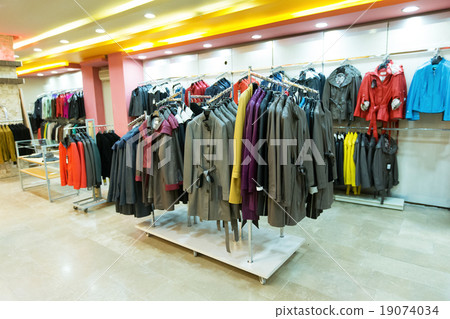 Stylish clothes on hangers in shop Stylish clothes on hangers in shop 19074034