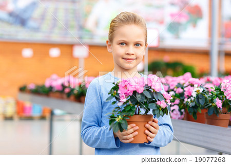 Little girl holding a blooming flower.  19077268