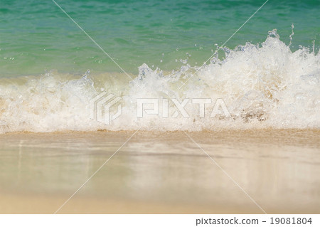 Wave washing up onto sand beach. 19081804