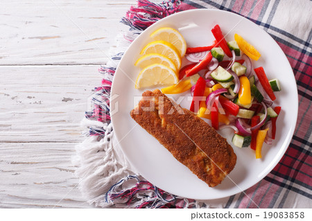 fried fish fillet with fresh vegetables and lemon 19083858