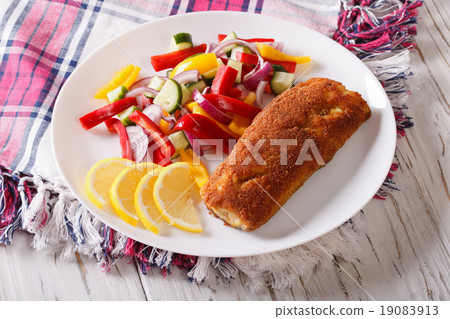 fried fish fillet with fresh vegetables on a plate 19083913