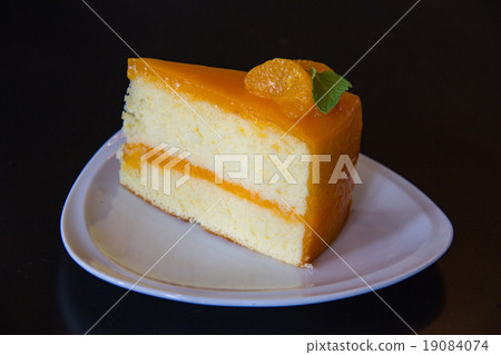 orange cake with orange topping in wooden dish orange cake with orange topping in wooden dish 19084074