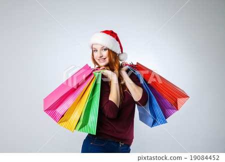 girl in winter hat with shopping bags over gray girl in winter hat with shopping bags over gray 19084452