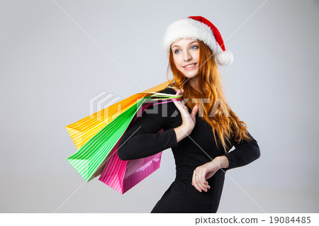 girl in winter hat with shopping bags over gray  19084485