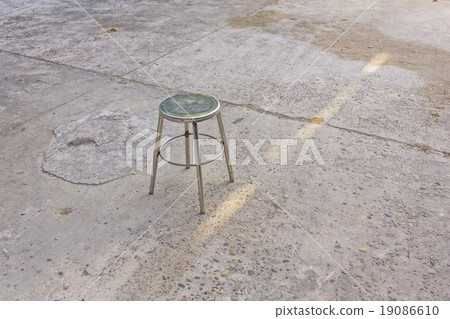 Steel chair on concrete floor background Steel chair on concrete floor background 19086610