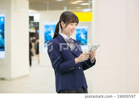 Female high school student's pose standing in the underground passage of the station 19089597
