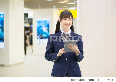 Female high school student's pose standing in the underground passage of the station 19089693