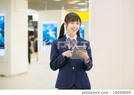 Female high school student's pose standing in the underground passage of the station 19089694