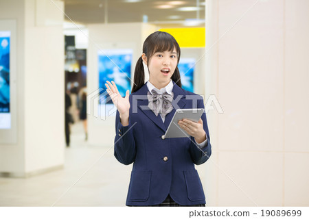 Female high school student's pose standing in the underground passage of the station 19089699