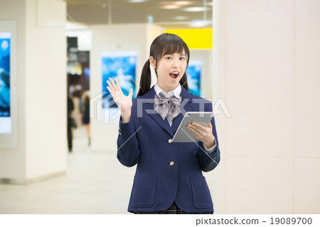 Female high school student's pose standing in the underground passage of the station 19089700