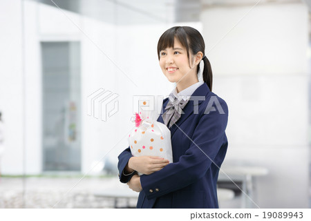Girls high school girl posing in uniform holding a present Girls high school girl posing in uniform holding a present 19089943