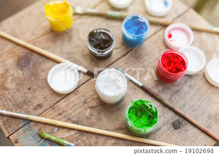 Brushes with colorful paints on old wood Brushes with colorful paints on old wood 19102698