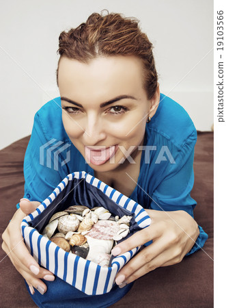 Crazy young woman with various shells in sailor bag 19103566