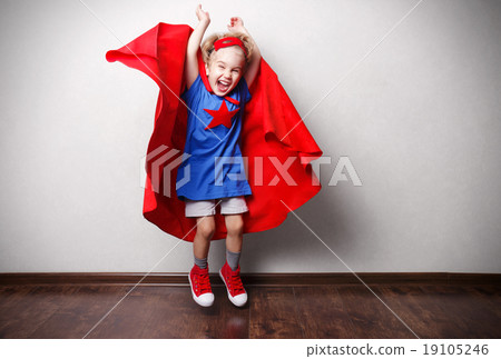 Happy child in superhero suit against gray wall. 19105246