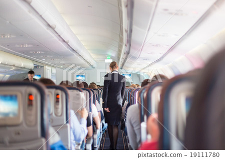 Stock Photo: Stewardess and passengers on commercial airplane.