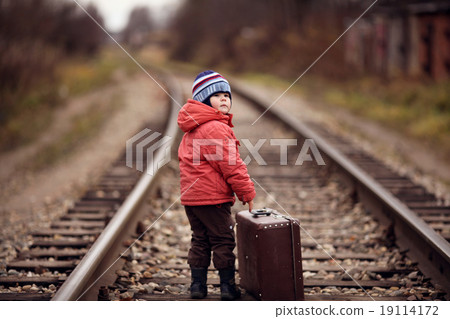 little traveler with a suitcase on the railroad 19114172