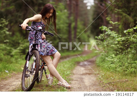 young girl on a sports bike in a summer forest young girl on a sports bike in a summer forest 19114817