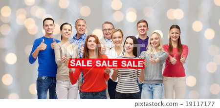 happy people with red sale sign showing thumbs up happy people with red sale sign showing thumbs up 19117177