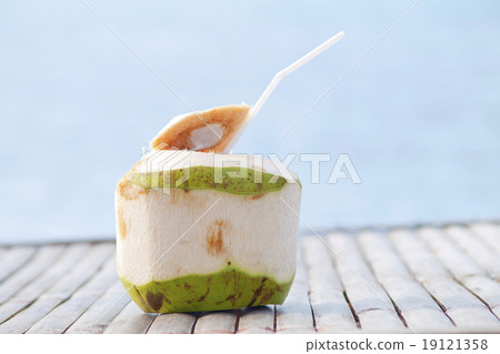 Coconut Water Drink on bamboo table with sea background 19121358