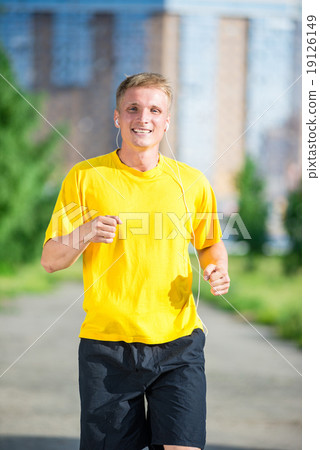 Sporty man jogging in city street park. Outdoor fitness. Sporty man jogging in city street park. Outdoor fitness. 19126149