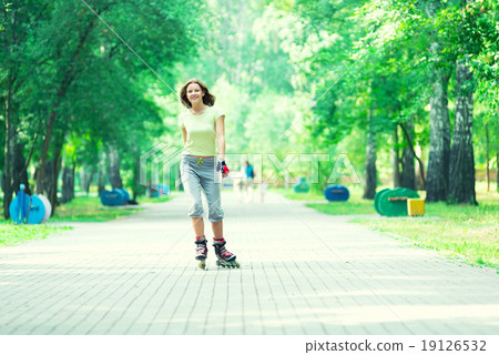 Roller skating sporty girl in park rollerblading on inline skate Roller skating sporty girl in park rollerblading on inline skate 19126532